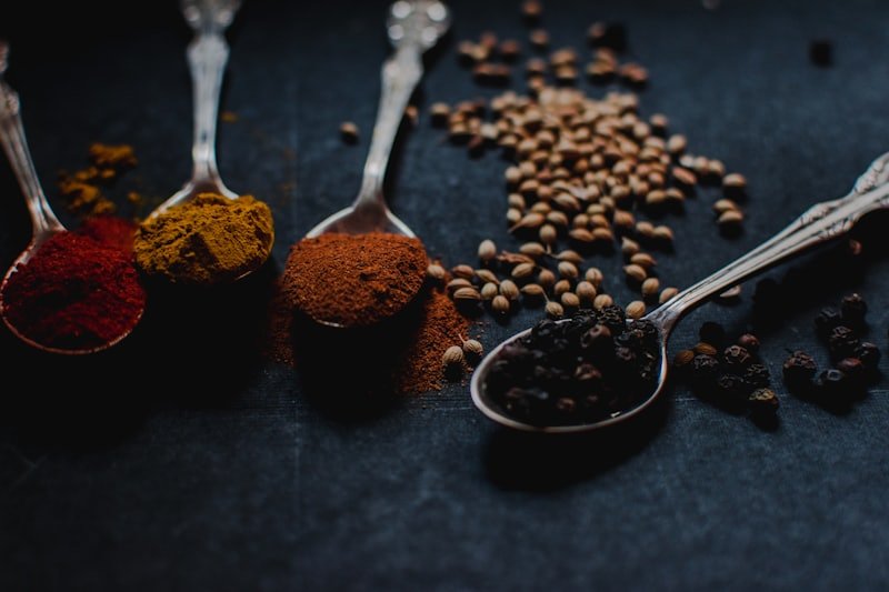 Assorted ground spices measured into spoons
